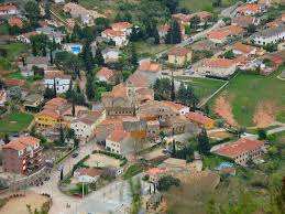 Fontanero Bigues i Riells, calle pintoresca con casas tradicionales y paisaje natural al fondo.