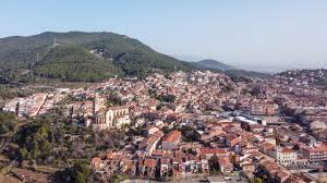 Fontanero Castellar del Vallès: Calle principal con edificios modernos y montañas al fondo