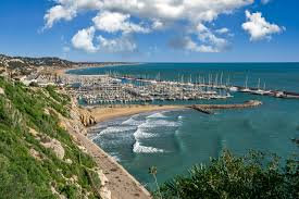 Fontanero Castelldefels: vista de canal olímpico y edificios modernos reflejados en el agua al atardecer en Castelldefels