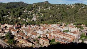 Fontanero Castellví de Rosanes reparando tubería junto a calle adoquinada y casas históricas del municipio.