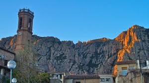 Fontanero Collbató en pintoresca calle con vistas a Montserrat y edificios históricos en el casco antiguo.
