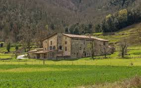 Fontanero Fogars de Montclús, calle con casas rurales tradicionales y paisaje montañoso de fondo.