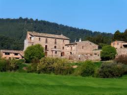 Fontanero Fonollosa en una calle tranquila con edificaciones rurales y montañas de fondo en el pueblo de Fonollosa