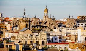 Fontanero La Llagosta: calle céntrica con edificios de ladrillo y fontanero trabajando en una tubería exterior