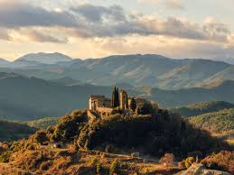 Fontanero L'Espunyola vista calle con casas de piedra y montañas al fondo en tranquilo pueblo catalán