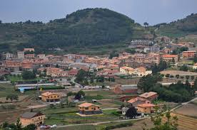 Fontanero L'Estany calle pintoresca con casas de piedra, paisaje natural y fontanero trabajando en tuberías