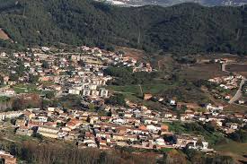 Fontanero Martorelles: vista de calle empedrada con casas rústicas y montañas al fondo, típica de la localidad catalana.
