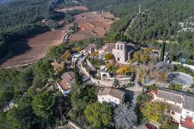 Fontanero Olivella calle empedrada con casas tradicionales rodeadas de vegetación mediterránea y colinas cercanas