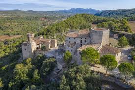 Fontanero Orpí: calles con casas rurales de piedra, paisaje montañoso y cielo claro de un pueblo catalán encantador.