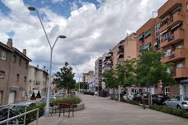 Fontanero Polinyà, vista de una calle céntrica con edificios residenciales modernos y jardines bien cuidados.