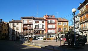 Fontanero Prats de Lluçanès camina por calle empedrada junto a edificios históricos del pueblo en un día soleado