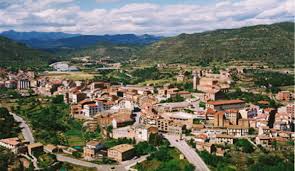 Fontanero Puig-reig: vista de una calle céntrica con edificios históricos y locales comerciales característicos.