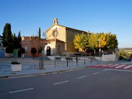Fontanero Puigdàlber calle estrecha con casas de piedra y flores coloridas en balcones, encanto rural de la ciudad