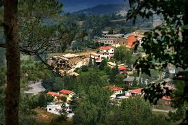 Fontanero Sant Agustí de Lluçanès, calle típica con casas de piedra y montañas al fondo.