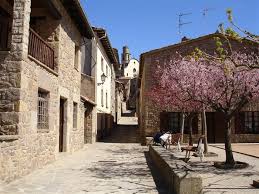 Fontanero Sant Boi de Lluçanès calle estrecha con casas de piedra típicas y un fontanero trabajando