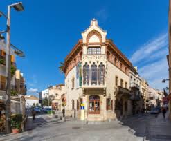 Fontanero Sant Cebrià de Vallalta calle arbolada con casas tradicionales y montañas al fondo en día soleado