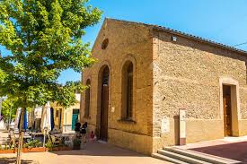 Fontanero Sant Llorenç d'Hortons reparando una tubería en calle con casas de piedra y montañas de fondo