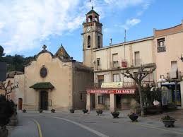 Fontanero Sant Llorenç Savall reparando tuberías cerca de la iglesia del pueblo con su furgoneta en la calle principal