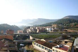 Fontanero Sant Martí de Centelles reparando tuberías en calle estrecha con casas de piedra y montañas al fondo