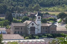 Fontanero Sant Mateu de Bages en una calle estrecha con casas de piedra y herramientas de plomería visibles