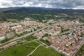 Fontanero Sant Vicenç de Castellet calle céntrica con iglesia histórica y montañas al fondo cielo despejado