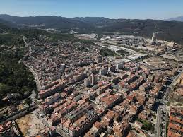 Fontanero Sant Vicenç dels Horts revisando tuberías en una calle con casas tradicionales y montaña al fondo