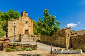 Fontanero Tavèrnoles calle con edificios de piedra y montaña al fondo ambiente tranquilo y pintoresco