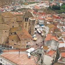 Fontanero Tordera en calle típica con casas de piedra y simpáticos balcones floridos, ambiente acogedor.