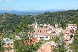 Fontanero Vacarisses, calle con casas de piedra y fondo de montañas, ambiente tranquilo y acogedor.
