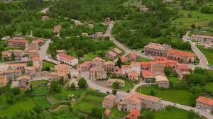 Fontanero Vallcebre: calle tranquila con casas de piedra y montañas al fondo en pintoresco pueblo catalán.