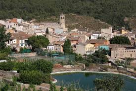 Fontanero Veciana en una pintoresca calle empedrada de Veciana con casas de piedra y flores en los balcones.