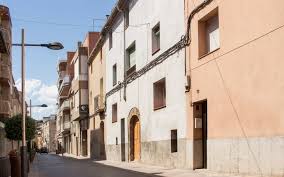 Fontanero Vilanova del Camí frente a casas tradicionales con calles arboladas y cielo despejado.